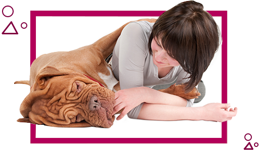 A woman laying on the ground with her dog.