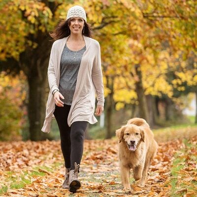 A woman walking her dog in the park.